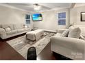Inviting living room featuring a plush sofa, armchair, stylish rug, ottoman and a wall-mounted TV for relaxation at 620 Millstream Dr, Rock Hill, SC 29732