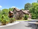 Beautiful two-story brick home featuring a circular driveway and lush landscaping, including roses and mature trees at 633 Elmhurst Dr, Fort Mill, SC 29715