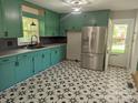 Bright kitchen featuring vibrant green cabinetry, stainless steel appliances, and starburst patterned floor at 805 Mark Dr, Shelby, NC 28152