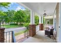 Inviting front porch featuring brick columns, white railings, and comfortable seating at 10102 Tolleson Ave, Charlotte, NC 28277