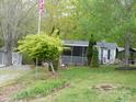 Landscaped yard with windmill, storage shed, porch, and mature trees at 124 Hummingbird Cir, New London, NC 28127