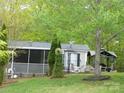 Home with screened in porch, outdoor gazebo, landscaping, and mature trees at 124 Hummingbird Cir, New London, NC 28127