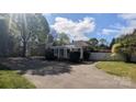 Spacious driveway leading to home with pergola covered porch; landscaped with mature trees at 1404 Oakdale Rd, Rock Hill, SC 29730