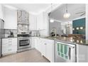 Modern kitchen featuring stainless steel appliances, white cabinetry, and granite countertops at 141 Rose St, Mooresville, NC 28117