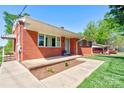 Charming brick home featuring a cozy front porch with a well-manicured lawn and landscaping at 1410 Beverly Ave, Shelby, NC 28152