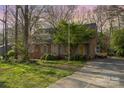 Quaint brick home with mature trees creating a serene environment; a welcoming entrance with a concrete driveway at 1620 Edgefield Ave, Gastonia, NC 28052
