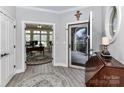 Elegant home foyer featuring wood flooring, classic trim and an arched opening to the office at 1805 Axholme Ct, Waxhaw, NC 28173
