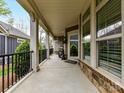 Inviting front porch with stone accents, white pillars, and black railing at 1805 Axholme Ct, Waxhaw, NC 28173
