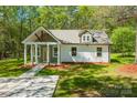Inviting home with a covered porch, surrounded by a green lawn at 208 Spinners Dr, Cherryville, NC 28021