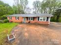 Quaint single-Gathering home featuring a brick facade, a metal roof, and classic black shutters at 2116 Dana Pl, Shelby, NC 28152