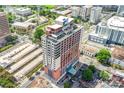 High-angle aerial view of the building with terrace, parking garage, landscaping, and urban surroundings at 222 S Caldwell St # 1510, Charlotte, NC 28202