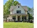 Charming two-story home with a inviting front porch, lush lawn and an entry door with glass pane at 2309 Pinckney Ave, Charlotte, NC 28205