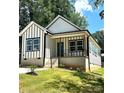 The new construction home features board and batten siding, a front porch with a blue door and modern landscaping at 2350 14Th Street Ne Ct, Hickory, NC 28601