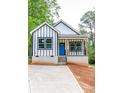 A white home with black trim features a bright blue front door and freshly poured concrete driveway at 2350 14Th Street Ne Ct, Hickory, NC 28601