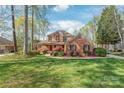Beautiful two-story brick home with lush green lawn and mature trees, offering a serene and picturesque setting at 255 Fernbrook Dr, Mooresville, NC 28117