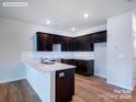 Modern kitchen features dark wood cabinetry, white countertops, and stainless steel sink with a tiled backsplash at 2579 Ruby Dixon Crossing Dr # 12, Gastonia, NC 28056