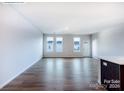 Open concept living room with hardwood floors and modern kitchen featuring a breakfast bar at 2579 Ruby Dixon Crossing Dr # 12, Gastonia, NC 28056
