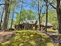 Brick home nestled among mature trees, providing privacy and a sense of tranquility at 271 Ikerd Se Dr, Concord, NC 28025