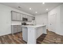 Modern kitchen with gray cabinetry, stainless appliances, and a center island with quartz countertops at 277 Bezelle Ave, York, SC 29745