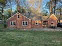 Backyard view of a brick home featuring a stone patio and a lush green lawn at 310 S Poston St, Shelby, NC 28150