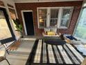 Sunroom with black and white striped rug, potted plants, and comfortable seating at 310 S Poston St, Shelby, NC 28150