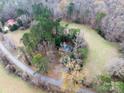 An aerial view captures a cozy home nestled within a wooded landscape and a winding road at 3713 Capricorn Rd, Lancaster, SC 29720