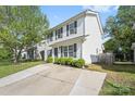 Side view of a two-story home with light siding and black shutters with a well-manicured lawn and driveway at 415 French St, Charlotte, NC 28216