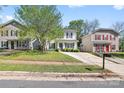 Street view of a charming two-story home with light siding, black shutters, and a well-manicured lawn at 415 French St, Charlotte, NC 28216
