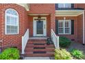 Close-up of the front entrance with brick steps, a black door, and manicured greenery at 4333 Sawmill Trace Dr, Charlotte, NC 28213
