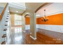 Open-concept space with hardwood floors, archways, staircase, and a decorative chandelier at 4333 Sawmill Trace Dr, Charlotte, NC 28213