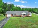 Beautifully landscaped front yard with a classic brick home and attached garage at 4462 Flat Creek Rd, Heath Springs, SC 29058