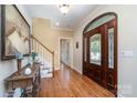 Elegant foyer with hardwood floors, a decorative front door, and staircase at 6419 Gilead Rd, Huntersville, NC 28078