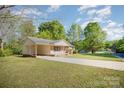 Home exterior with a long driveway, large lawn, a covered carport and plenty of nature views at 700 Fine Wright Ave, York, SC 29745