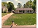 Well-manicured lawn surrounds this single-story home with a long driveway at 7428 Beaufort Cir, Charlotte, NC 28227