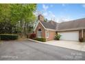Beautiful exterior showcasing an attached garage, and landscaped garden under a sunny sky at 7444 Hurstbourne Green Dr, Charlotte, NC 28277