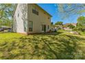A spacious back yard featuring lush grass and mature trees offering a serene outdoor retreat and space to relax at 8719 Sweet Sage Ln, Charlotte, NC 28227