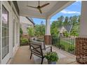 Relaxing front porch with seating, ceiling fan, brick pillars, and black metal railings at 911 Naples Dr, Davidson, NC 28036