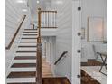 Elegant staircase with wood treads, white risers, shiplap walls, and decorative wood railing leading to the second floor at 911 Naples Dr, Davidson, NC 28036
