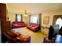 Inviting living room featuring a brick fireplace, plush seating, and natural light from the windows at 1014 Stuart Dr, Wadesboro, NC 28170