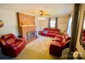 Comfortable living room with a classic brick fireplace, ceiling fan, and supple leather furniture at 1014 Stuart Dr, Wadesboro, NC 28170