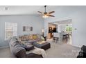 Spacious open concept living room featuring plush sectional sofa with ceiling fan and open view to kitchen at 105 Sterling Ter, Mooresville, NC 28115
