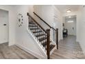 Elegant staircase with wooden handrail and modern design accents at 1077 Hearth Sw Ln, Concord, NC 28025