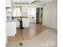 Bright eat-in kitchen with white cabinets, wood countertop, and a seamless transition to an adjacent carpeted room at 1230 Roberts St, China Grove, NC 28023