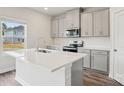 Charming kitchen with gray cabinets, island with white countertop, stainless appliances and wood flooring at 1240 Morehead Dr, Salisbury, NC 28144