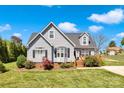 Charming two-story home featuring gray siding, a well-manicured lawn, and a welcoming front porch at 126 Top Flite Dr, Statesville, NC 28677