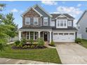 Charming two-story home with stone accents, a well-manicured lawn, and a two-car garage at 12710 Es Draper Dr, Huntersville, NC 28078