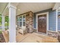 Inviting front porch with stone accents and comfortable seating area at 12710 Es Draper Dr, Huntersville, NC 28078