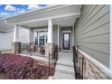Cozy front porch with seating area, stone pillars, and black railings, creating a welcoming entrance at 1497 Tranquility Blvd # 417, Lancaster, SC 29720