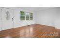 Bright living room featuring hardwood floors, a large window, and a white front door at 1500 19Th Avenue Ne Pl, Hickory, NC 28601