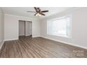 Bright living room featuring wood-look floors, a ceiling fan, and a large bay window at 1637 Buckingham Ave, Gastonia, NC 28054